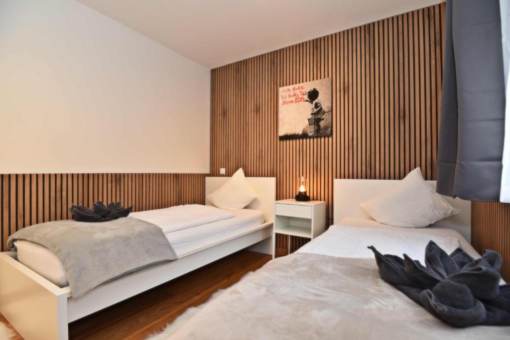 Zimmer mit zwei Betten vor Holzlamellenwand